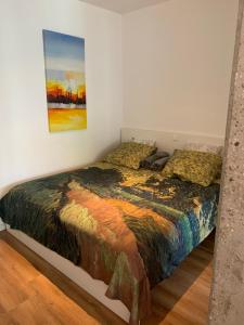 a bedroom with a bed with a painting on the wall at trendy STUDIO ROTTERDAM CENTER in Rotterdam