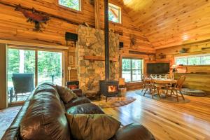 a living room with a leather couch and a fireplace at Lyndhurst Cabin on Farm with Pond and Stocked Stream! in Lyndhurst