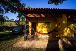 ein gelbes Haus mit einem davor geparkt in der Unterkunft Garça Branca in São Roque de Minas