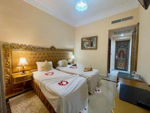um quarto de hotel com duas camas com lençóis brancos em Royal Victoria - Ex British Embassy em Tunes