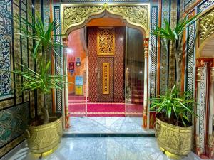 a lobby with two potted plants in front of a door at Royal Victoria - Ex British Embassy in Tunis