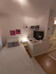 a bedroom with a bed and a desk with a television at White House in Chapeltown