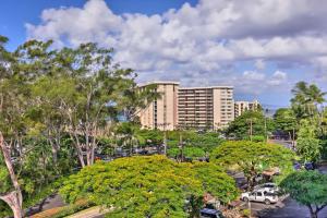 a large building in front of a parking lot with trees at Modern and Cozy Condo Near Beaches with Coastal Views in Kahana