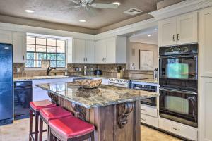a kitchen with a large island with red bar stools at Canyon Lake Home Hill Country and Water Views! in Canyon Lake
