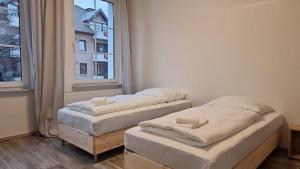 two twin beds in a room with a window at Tolstov House - 5 Room House with Terrace - 35 Min to Messe DUS in Mönchengladbach