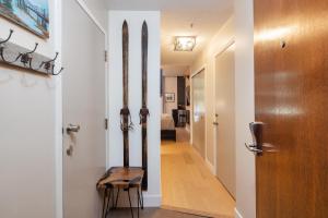 a hallway with a wooden door and a wooden chair at Impeccable Glacier Lodge Hotel Room w Pool+Hot Tub in Whistler