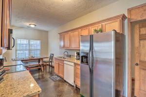 a kitchen with a stainless steel refrigerator and a table at Heber Springs Cabin about 1 Mi to Sugarloaf Mtn! in Heber Springs