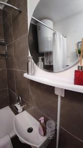 W łazience znajduje się biała toaleta i lustro. w obiekcie Studio apartman Bruna w mieście Ðakovo