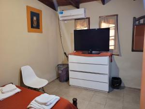 ein Schlafzimmer mit einem TV auf einer Kommode mit einem Bett in der Unterkunft Alto Hermoso Apart in Cordoba