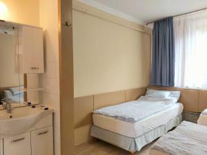 um pequeno quarto com uma cama e um lavatório em HAVAR Resort em Mátraszentimre