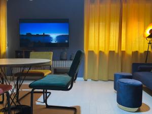 sala de estar con mesa, sillas y TV en LUxRO Home en Crotone