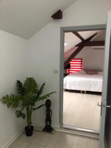 Zimmer mit einem Schlafzimmer mit einem Bett und einer Pflanze in der Unterkunft Alsacian Home - Old Town Cosy Apartments in Colmar