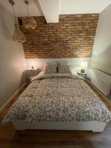 a bedroom with a brick wall and a large bed at APARTAMENTY GUZIK in Krosno