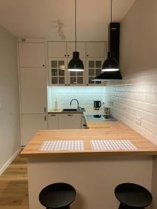 una cocina con barra y dos taburetes. en APARTAMENTY GUZIK en Krosno