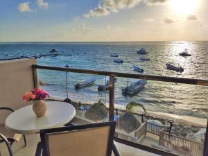 a balcony with a table and a view of the ocean at Hacienda Morelos Beachfront Hotel in Puerto Morelos