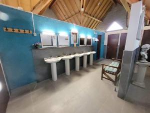 een badkamer met vier wastafels en een rij spiegels bij Stacaravan 6 persoons - Camping Le Soustran in Neuvic