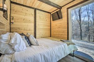 uma cama num quarto com uma grande janela em Tiny Home with Hot Tub By Mohican State Park! em Loudonville