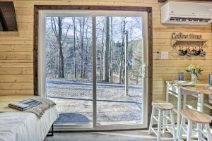 a sliding glass door in a bedroom with a table at Tiny Home with Hot Tub By Mohican State Park! in Loudonville