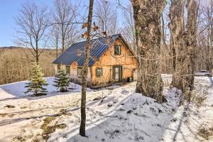 a log cabin with a blue roof in the snow at 8 Mi to Okemo Mtn Charming Ludlow Studio! in Ludlow