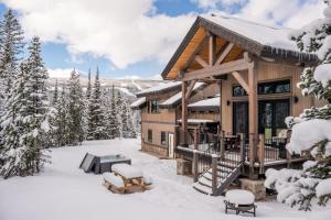 a log cabin in the snow with a grill at 360 Chalet in Big Sky