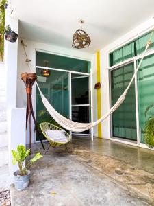 a hammock on the front porch of a house at Casa Daikiri in Puerto Escondido