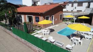 a patio with tables and chairs and umbrellas at Mare Blu - Pousada Hostel in Torres