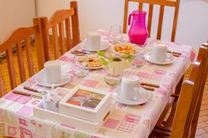 una mesa con un mantel rosa con comida. en Hospedaje Amilcar, en Esquel 16 fotos más