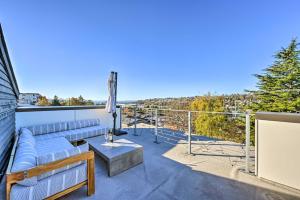 a patio with a couch and a table on a balcony at Sleek Seattle Home with Rooftop Patio and Views! in Seattle