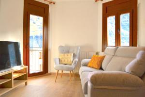 sala de estar con sofá y TV en Apartament comfortable amb vistes i cèntric by RURAL D'ÀNEU, en Esterri d'Àneu