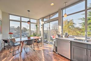 eine Küche mit einem Tisch, Stühlen und Fenstern in der Unterkunft Sleek Seattle Home with Rooftop Patio and Views! in Seattle