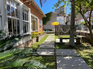 a building with a bench and a hammock outside of it at Mare Blu - Pousada Hostel in Torres