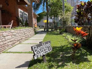 a sign in the grass in front of a house at Mare Blu - Pousada Hostel in Torres