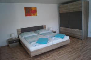 Un dormitorio con una cama con almohadas azules. en Ferienwohnungen Denk, en Niederalteich