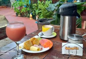 a drink and a plate of food on a table at Vila Shangri-la Algodoal- Suítes e Redário in Algodoal