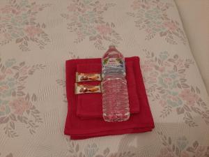 una botella de agua sentada en una servilleta roja en Chambre Privé dans belle maison 1 en Ettelbruck