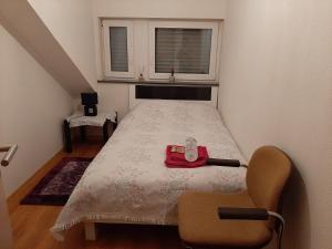 a small bedroom with a bed and a chair at Chambre Privé dans belle maison 1 in Ettelbruck