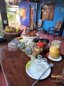 Vila Shangri-la Algodoal- Suítes e Redário في ألجودوال: طاولة عليها أطباق من المواد الغذائية والمشروبات