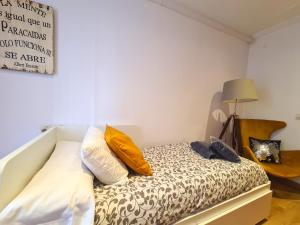 Dormitorio pequeño con cama con almohadas amarillas en Apartamentos Dos Torres pasaje de los Giles, en Zaragoza