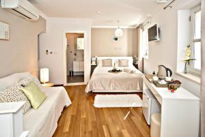 ein weißes Schlafzimmer mit einem Bett und einem Sofa in der Unterkunft Villa Daky in Split