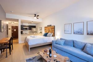 ein Wohnzimmer mit einem Bett und einem blauen Sofa in der Unterkunft Bright Suite at Ski In/Out Glacier Lodge! in Whistler