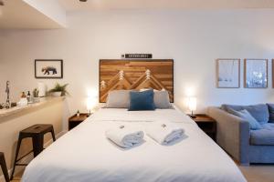 1 dormitorio con 1 cama grande y 2 toallas. en Bright Suite at Ski In/Out Glacier Lodge! en Whistler