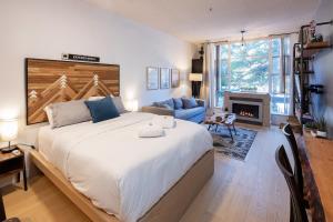 a bedroom with a large bed and a fireplace at Bright Suite at Ski In/Out Glacier Lodge! in Whistler