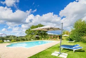 uma piscina com um guarda-sol e uma cadeira em Casa Ora d'Oro - PANORAMIC VIEWS / POOL / PRIVATE GARDEN em Trequanda