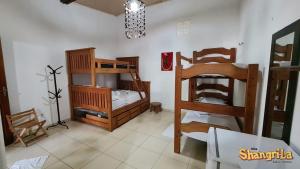 Vila Shangri-la Algodoal- Suítes e Redário في ألجودوال: غرفة بسريرين بطابقين وطاولة