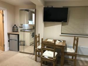 a kitchen with a table and chairs and a television at Fosse Paddock Country Studio 1 - Free Parking in Nottingham