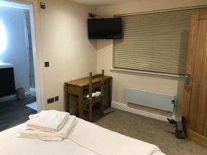 a bedroom with a bed and a desk and a window at Fosse Paddock Country Studio 1 - Free Parking in Nottingham