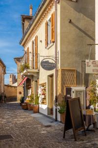 un edificio con un cartel frente a él en una calle en Civiconove Affittacamere en Gradara