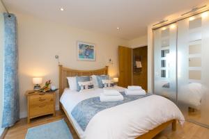 a bedroom with a large white bed with blue pillows at Beach Haven in Carbis Bay