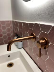 a bathroom sink with a brass faucet on a counter at De Kerck - bijzonder overnachten in Middelburg