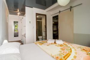 1 dormitorio con 1 cama blanca grande y toallas. en Casa Container Incrível no Campeche, 2 hóspedes SUL91 en Florianópolis